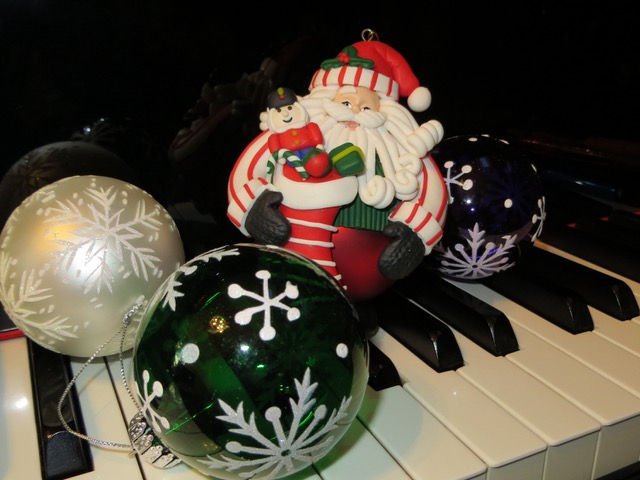 MainlyPiano.com home page image. A Santa ornament ball on the piano keys.